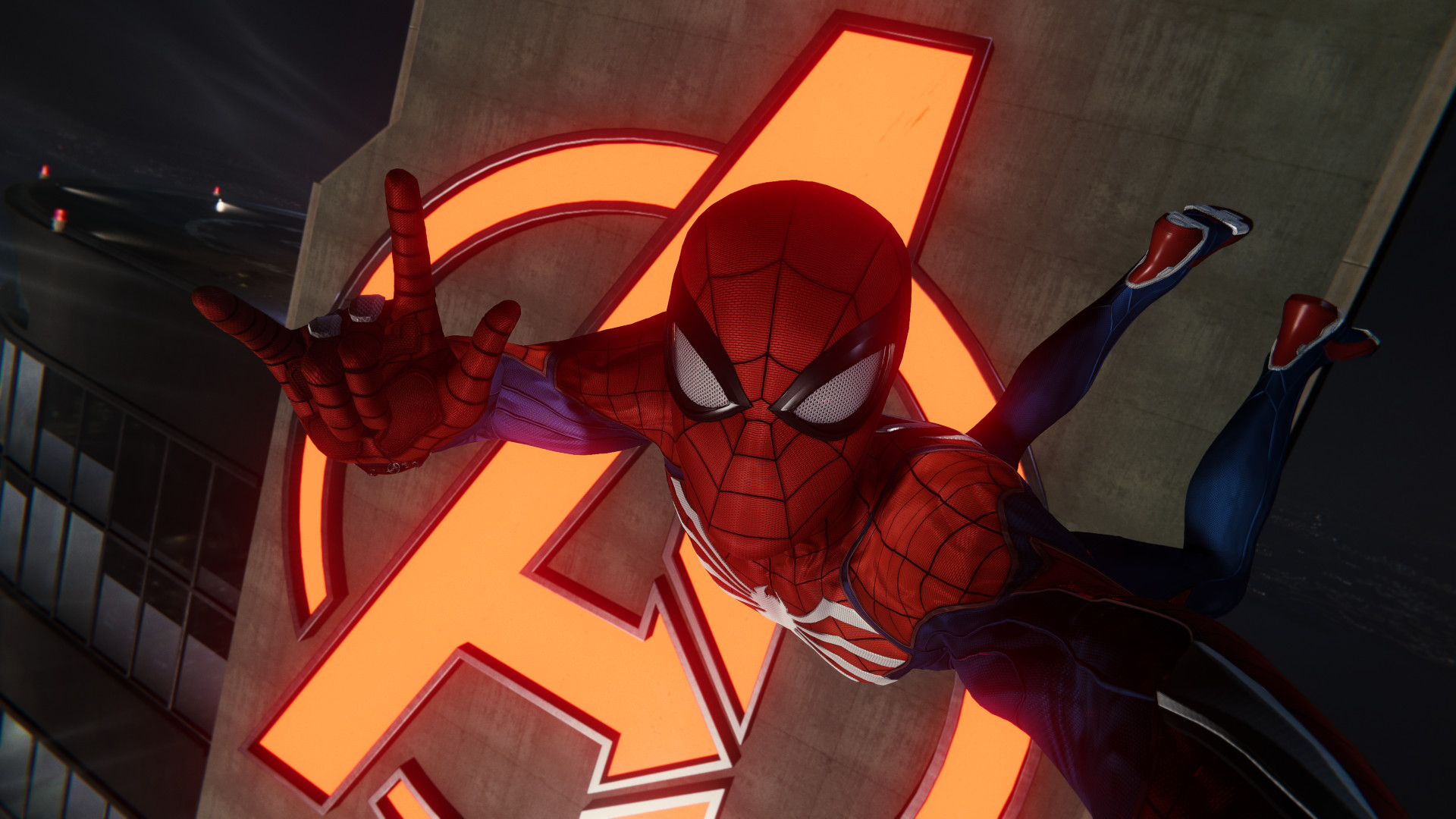 Marvel’s Spider-Man Remastered PC Review: Ein Selfie von Spidey, der uns mit seiner rechten Hand die Hörner gibt, vor dem Neonlicht des Avengers Tower